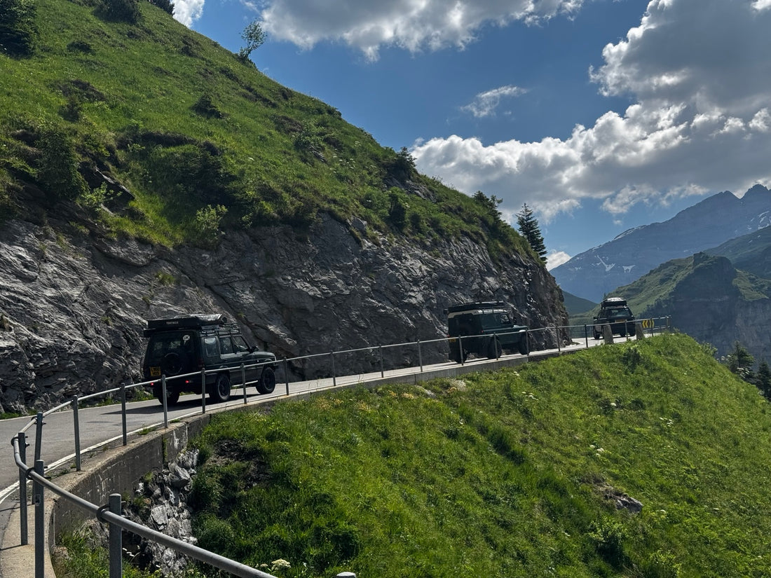 Land Rover Defender convoy driving a high alpine mountain pass